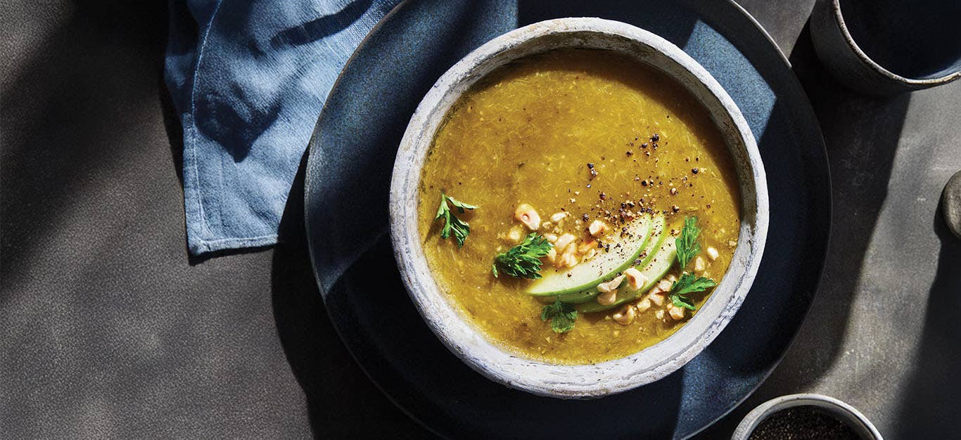 Leek, Apple, and Hazelnut Soup garnished with sliced apple, toasted hazelnuts, and fresh parsley